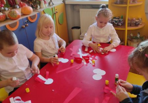 Dzieci wykonują kotylion biało- czerwony.